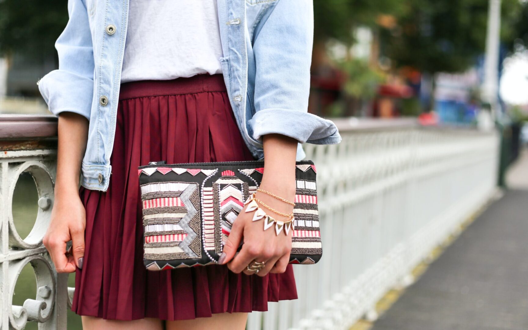 A woman holding onto her purse while wearing bracelets.