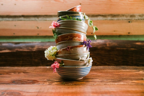 A stack of tin cans with flowers on top.