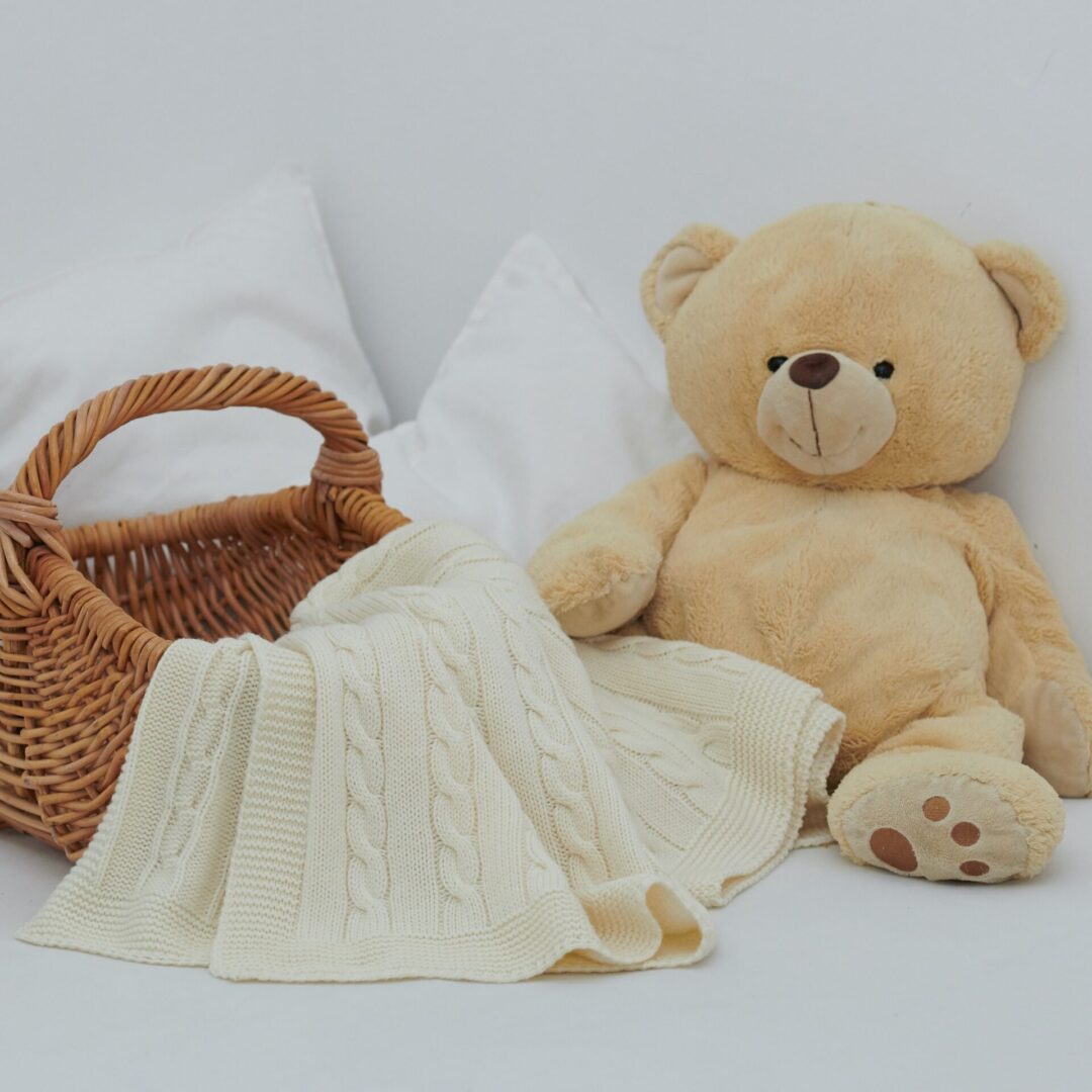 A teddy bear and blanket on the bed