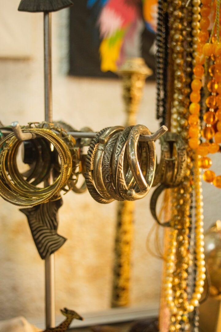 A rack of gold jewelry hanging on the wall.